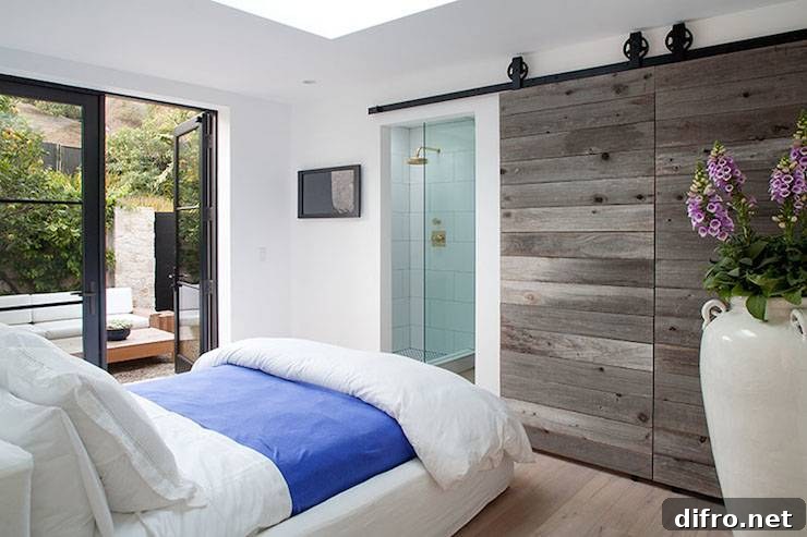 Rustic sliding barn doors open to reveal a glass-front shower.
