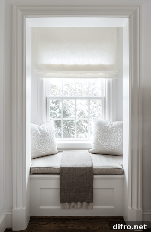 Small window seat nook is accented with a taupe cushion and pillows and a taupe linen throw blanket.