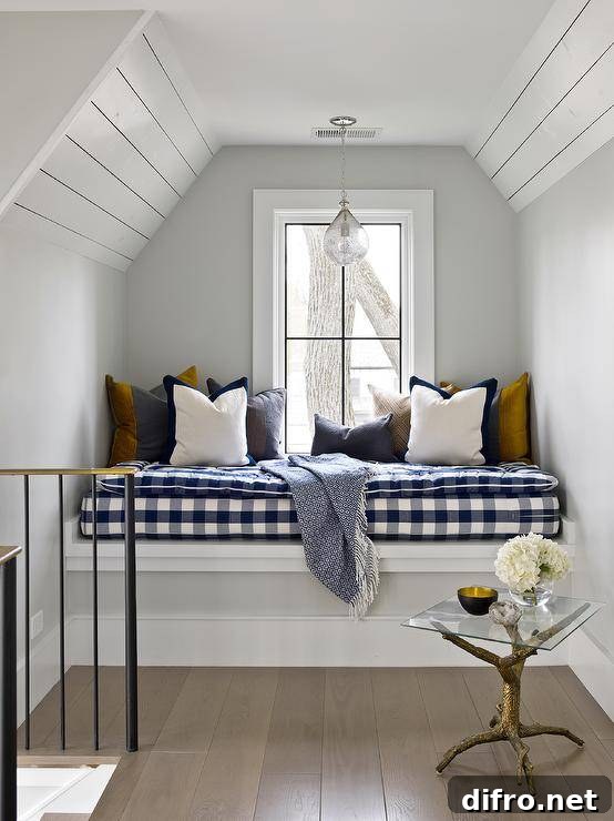 Attic window seat nook boasts a blue buffalo check cushion with various accent pillows and a gold faux bios accent table in a cottage home.
