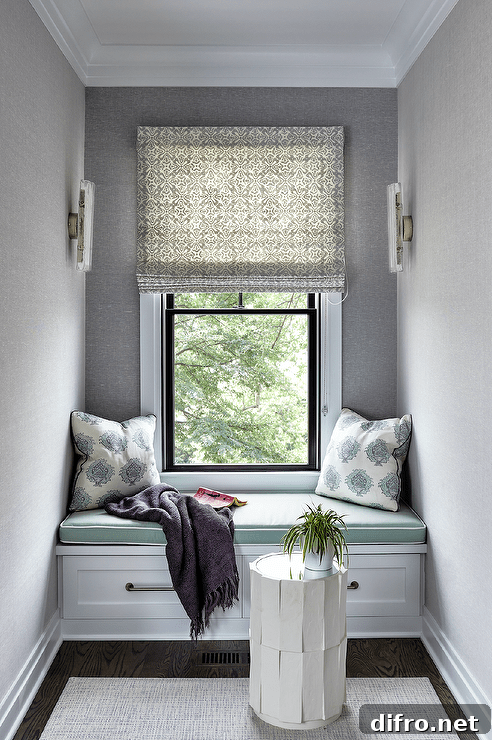 Window seat nook design with gray wallpaper features green seat cushions and blue block print pilows.