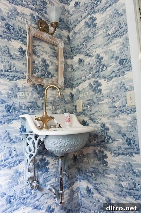 Powder room with Sapphire Blue Toile de Jouy wallpaper and vintage fixtures.