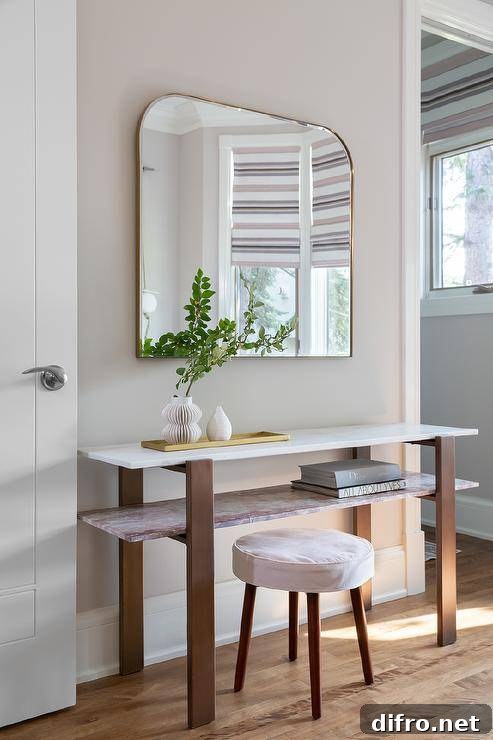 Entryway with pink marble console table and brass arch mirror