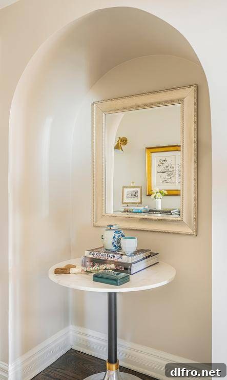 Arched alcove with silver leaf beaded mirror over a marble accent table