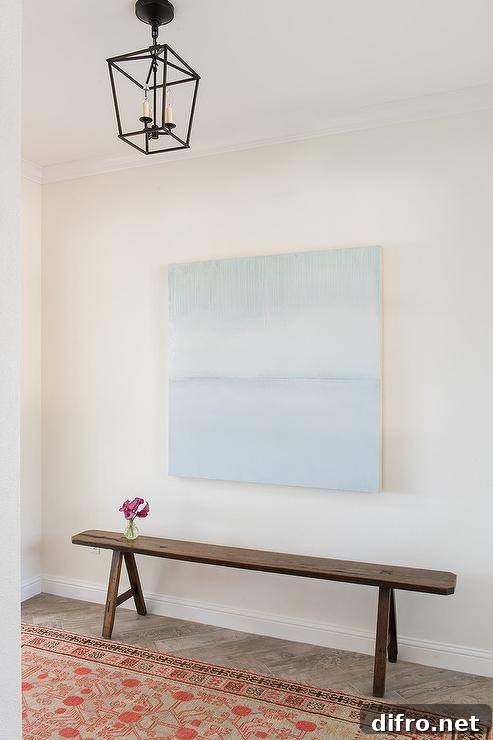 Blue abstract canvas art over a rustic bench and orange rug
