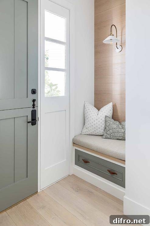 Cottage entryway with built-in bench and gray plank Dutch door