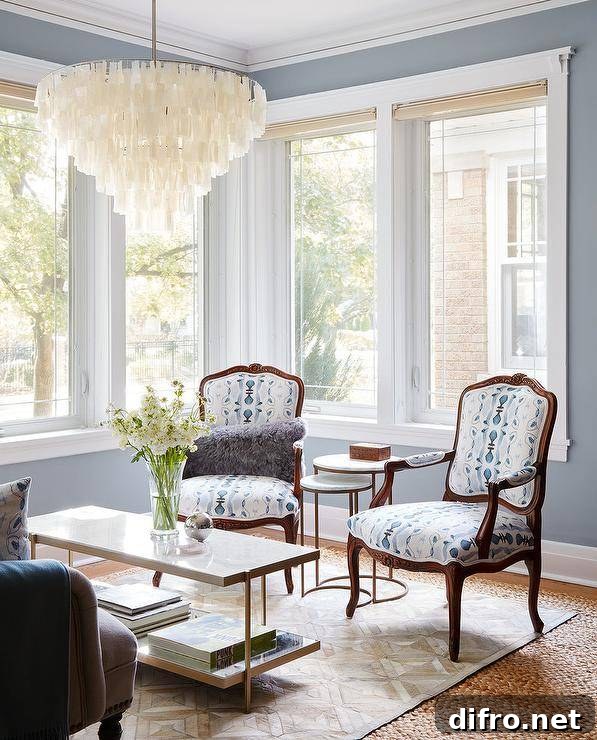 Make a room light and inviting by using soft blue walls with creamy white trim and neutral accents. The blue living room colors work well together and create an airy feel for a lit by a large white capiz chandelier over a brass and marble coffee table. Using multiples of items, such as the two white and blue French accent chairs, a gold parquet pattern rug and symmetry will give the room a sense of classic balance.