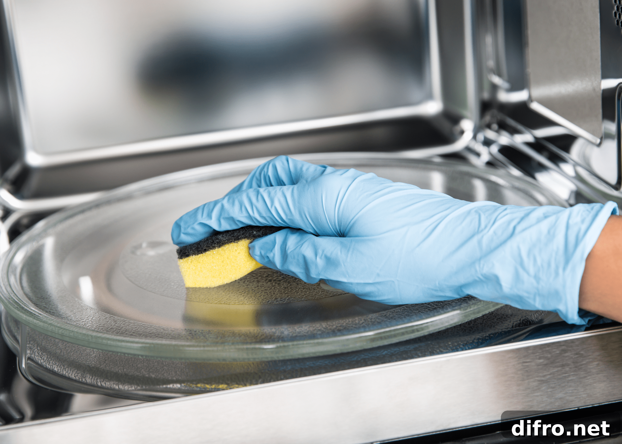 close up of cleaning microwave with sponge