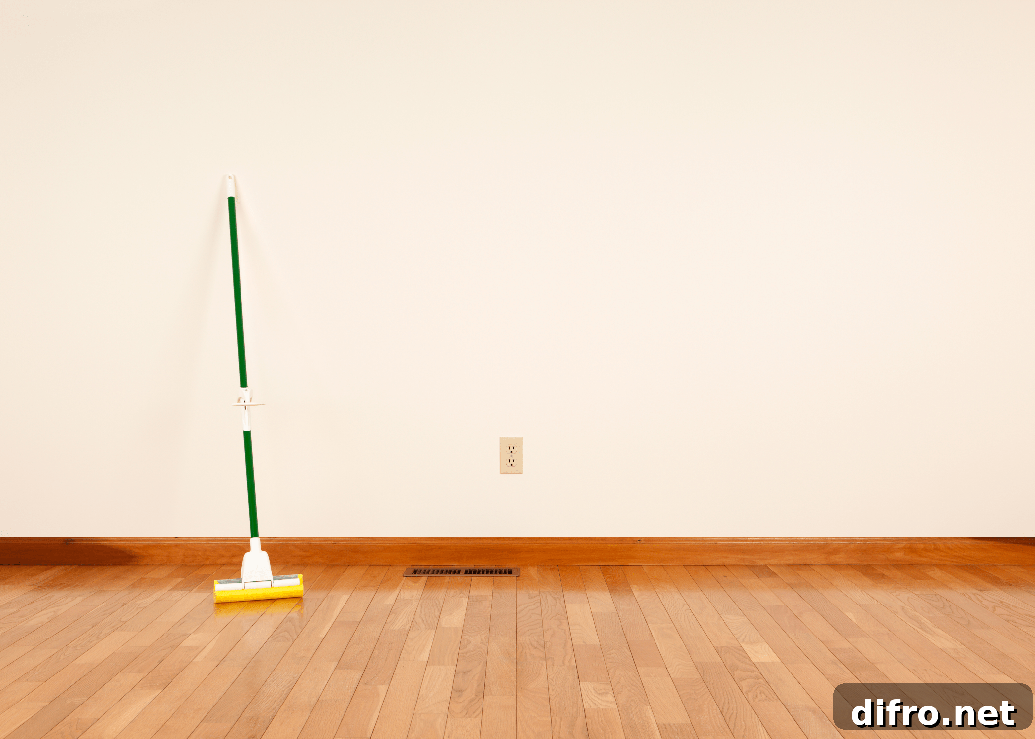 mop leaning up against white wall in an empty room