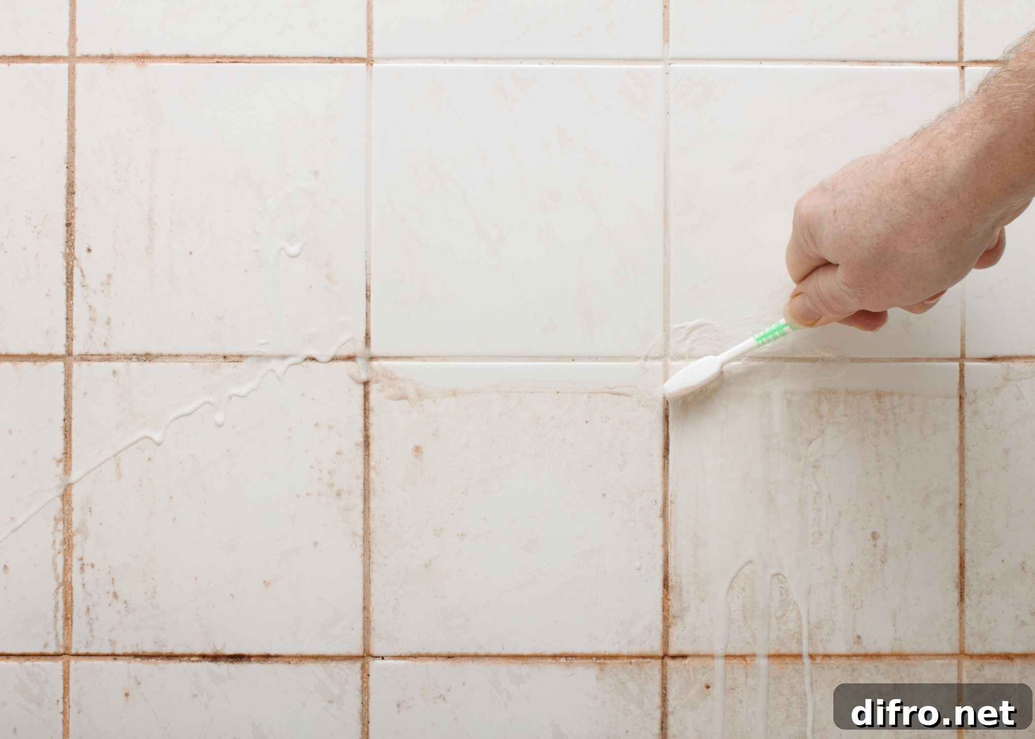 scrubbing dirty shower with toothbrush