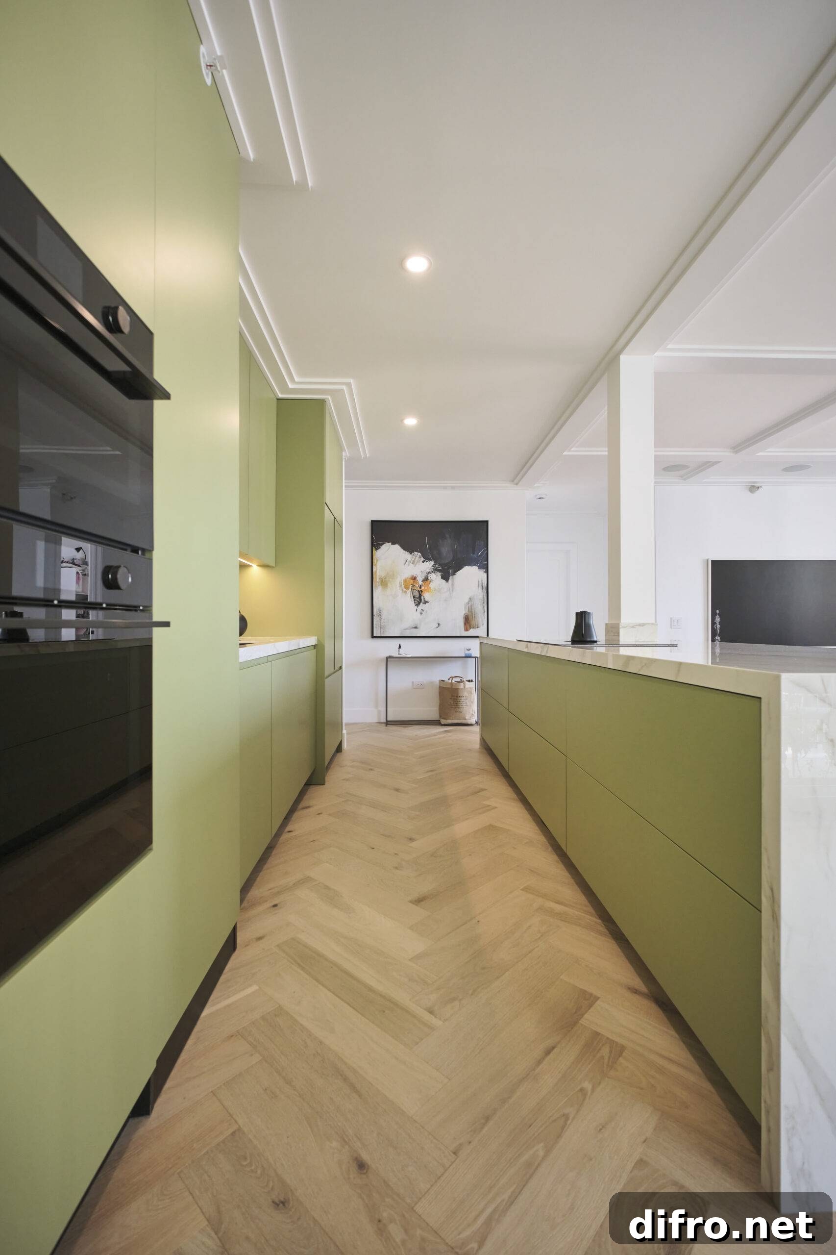 Sage green kitchen with white accents and light wooden floors.