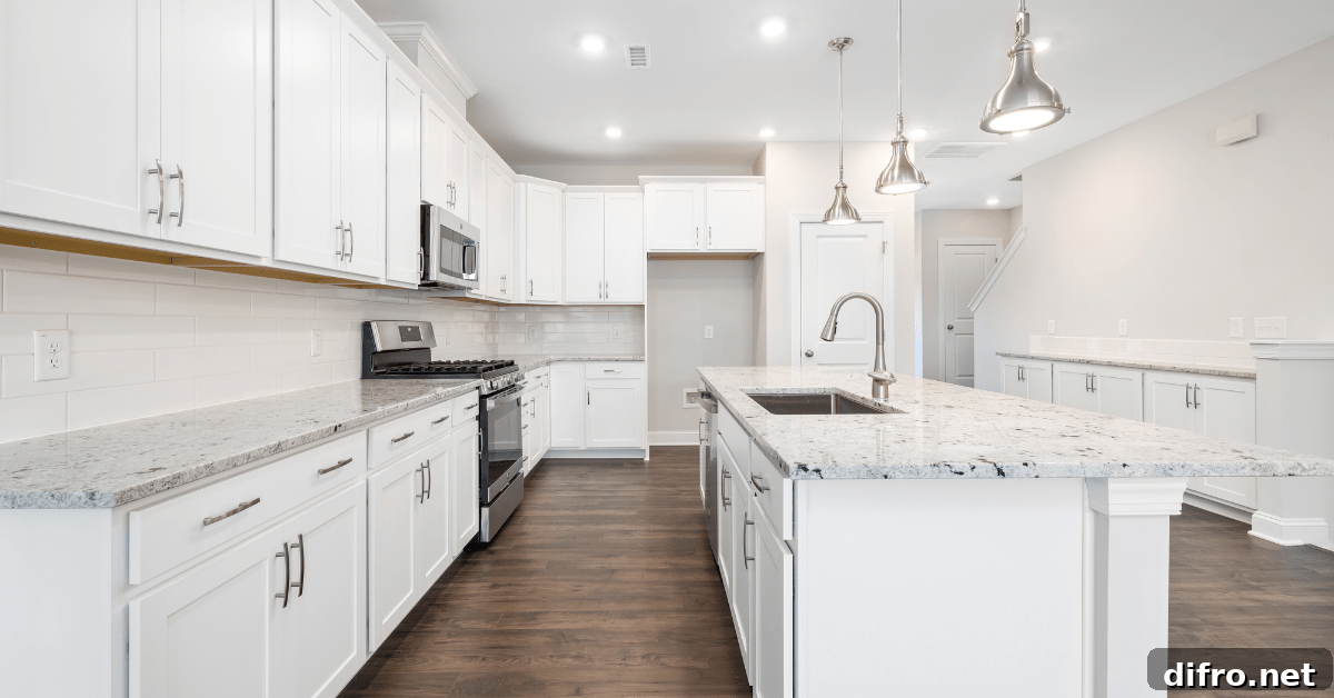 Marble counters in a modern kitchen with white cabinets.