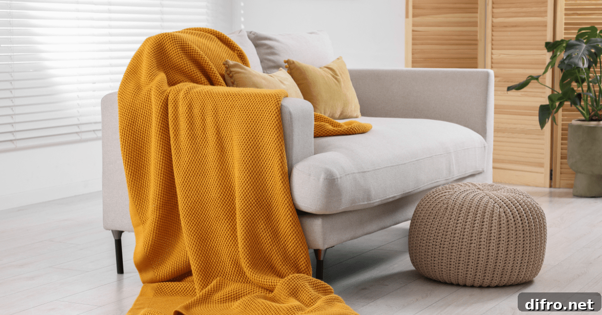 White couch with orange throw blanket