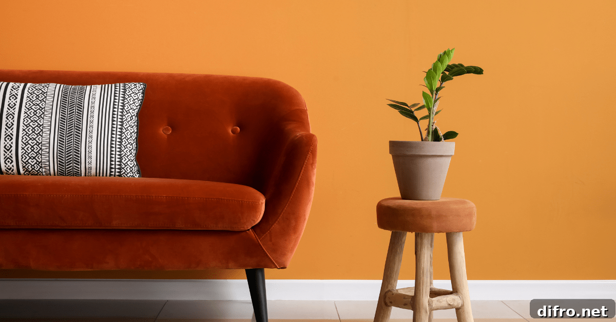 Orange wall and couch beside with a potted plant.