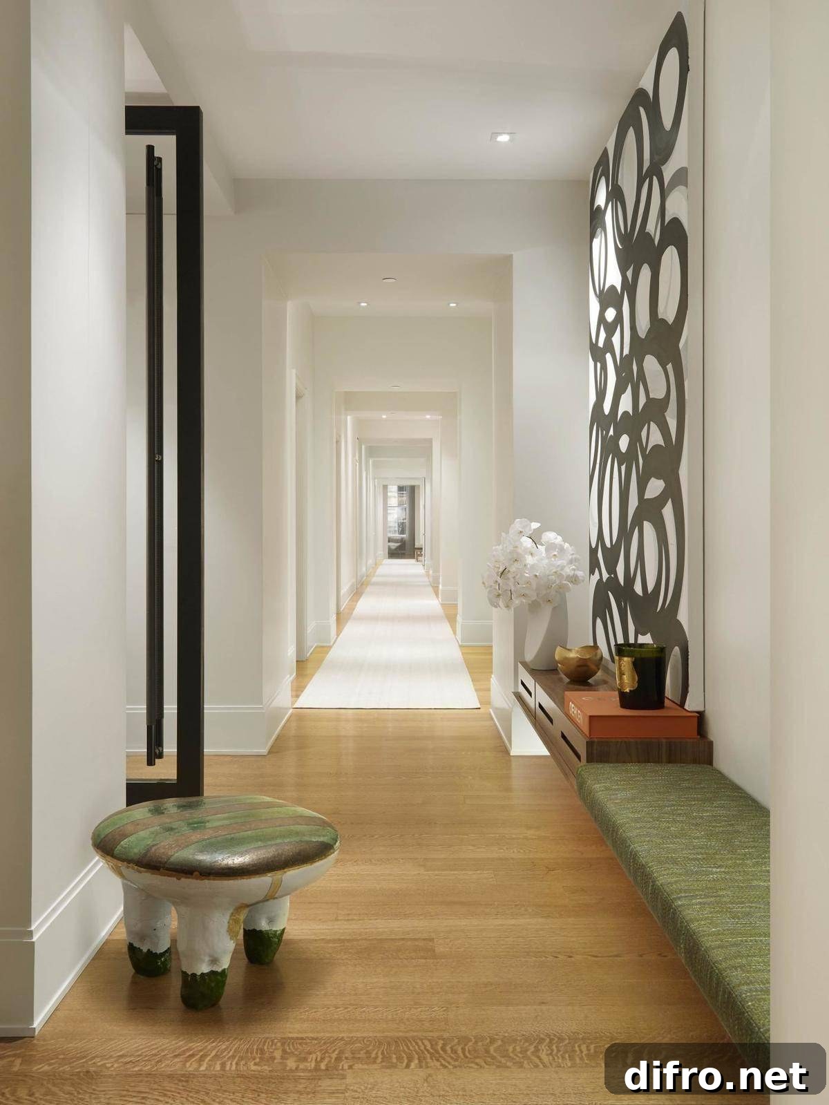 Long hallway with green furniture.