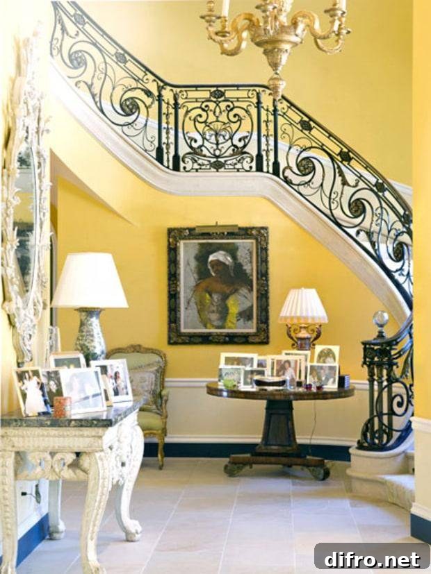 An entrance hall includes tables with personal photos, a yellow staircase, and a painting.