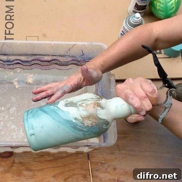 Person painting a vase.