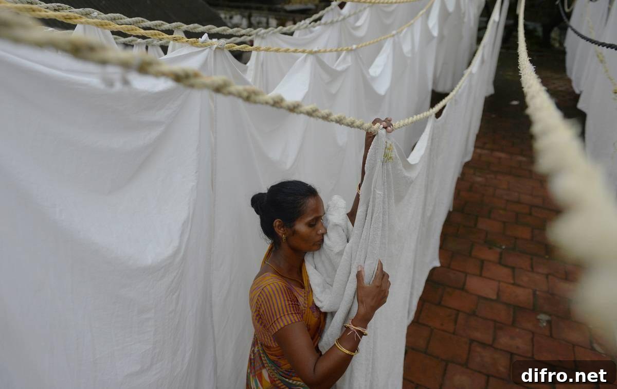 A woman hangs bed sheets to dry in India.