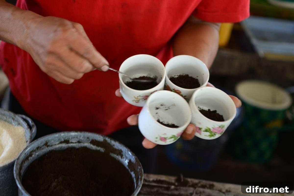 A man dishes coffee grounds from cups.