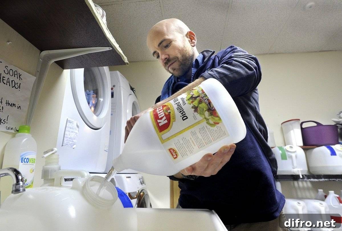 A man pours vinegar into water to clean.