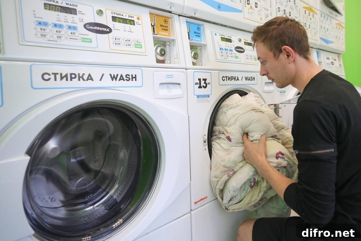 A man pushes laundry into a washing machine.