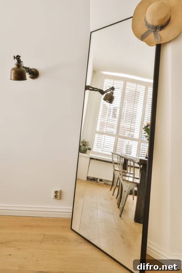 A mirror leaning against a wall, a table and chairs visible in its reflection.