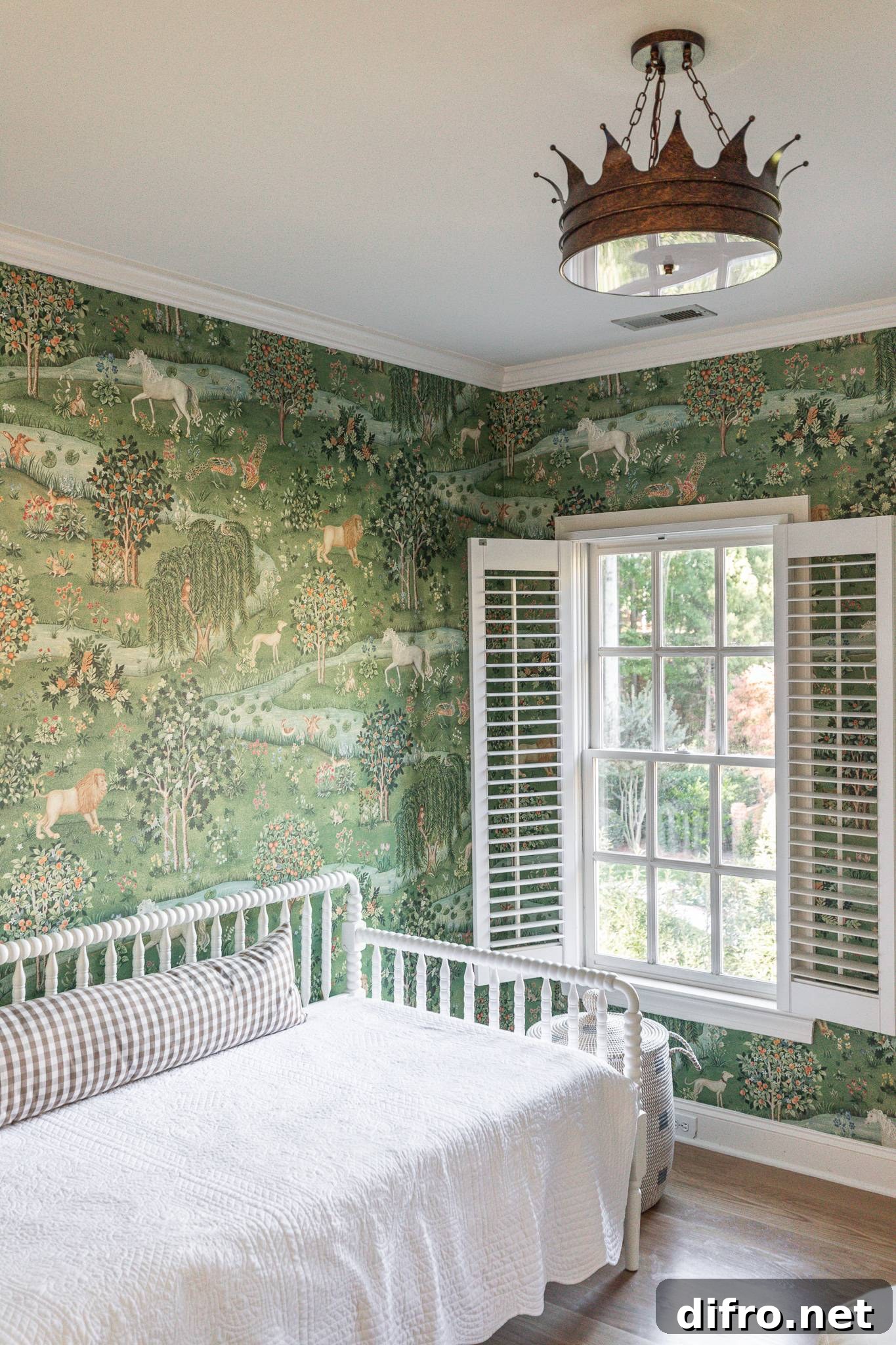 A bedroom with whimsical wallpaper, a bright window, bed, and statement lighting.