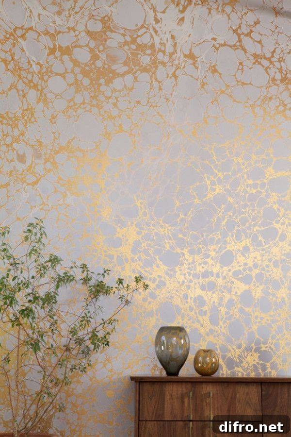 Metallic wallpaper on a wall, a chest with some decor in front.