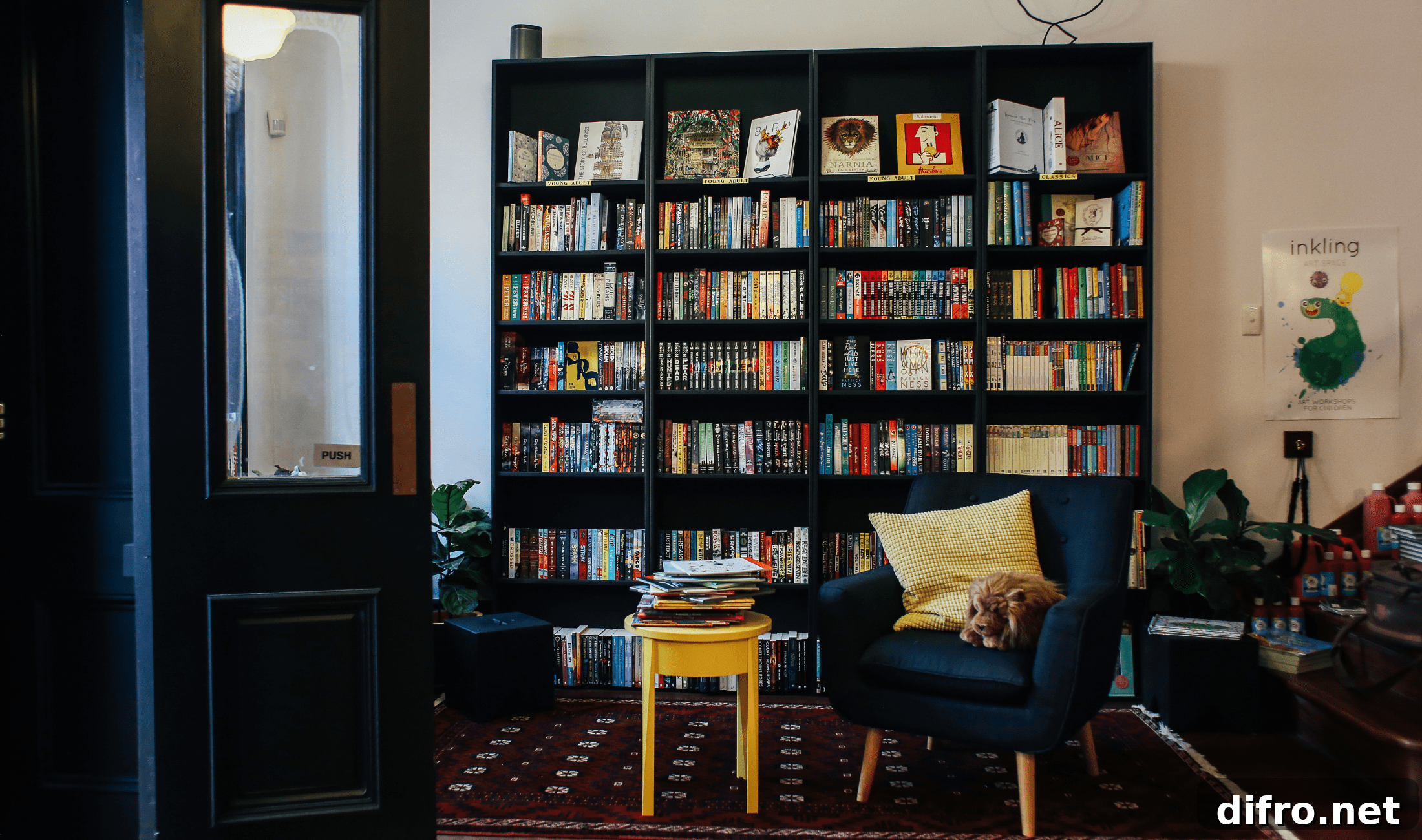 A large black bookshelf organized well in a living room.