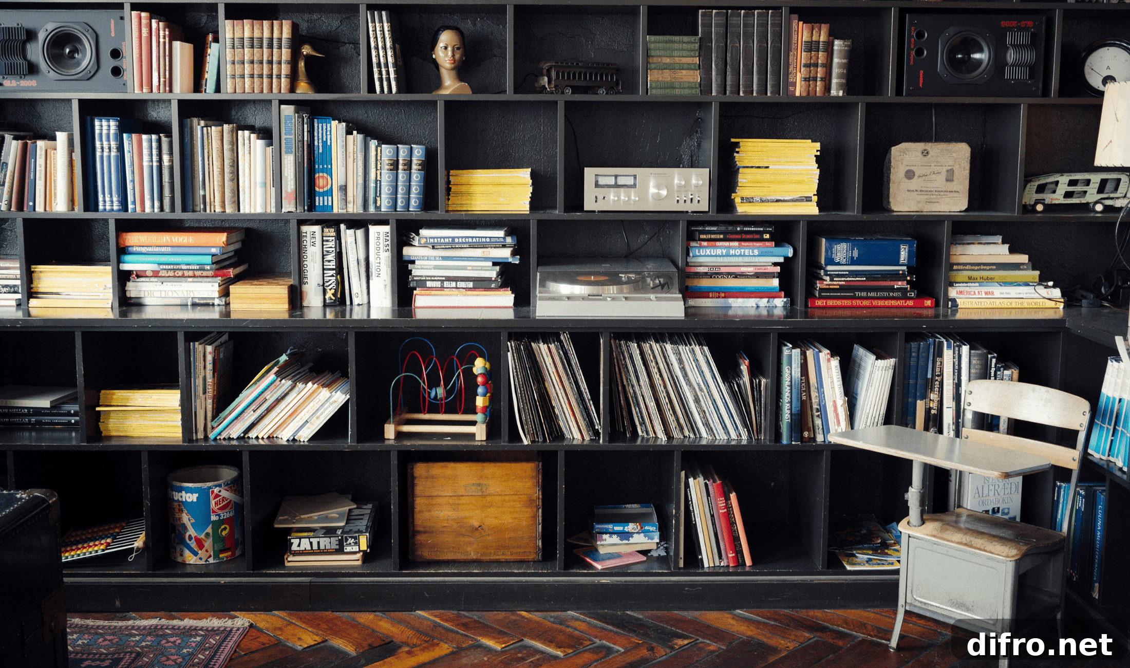 A large black bookshelf with a variety of objects on its shelves, a lot of visual diversity.
