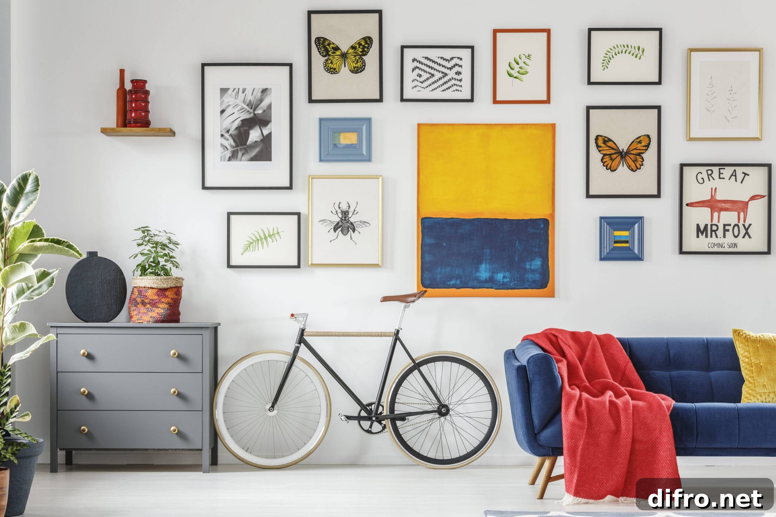 Red blanket on blue sofa next to bike in modern living room interior with posters.