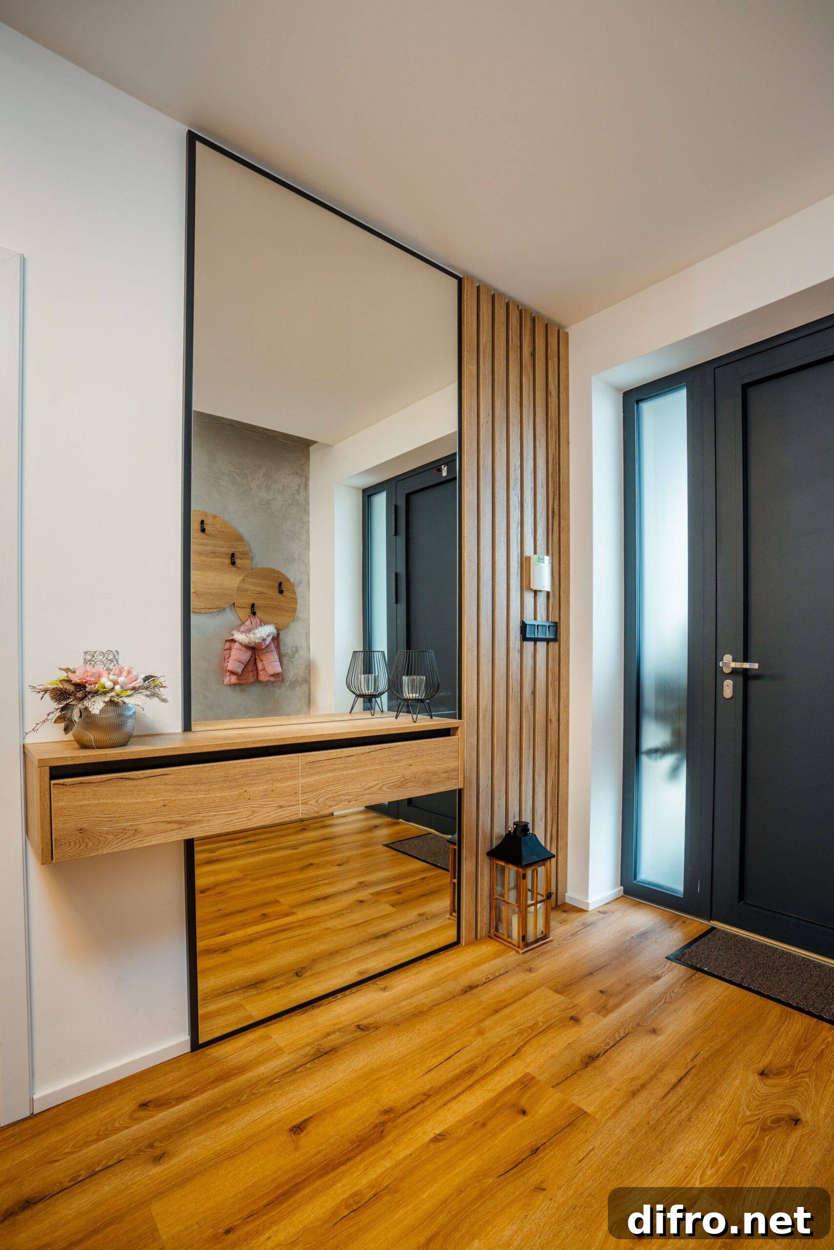 Contemporary entranceway with a large mirror and dark wooden flooring