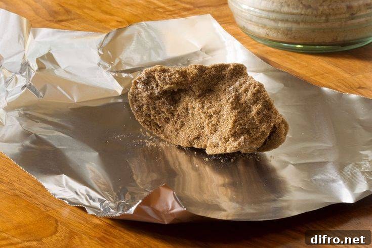 A hardened clump of brown sugar resting on a piece of tin foil.