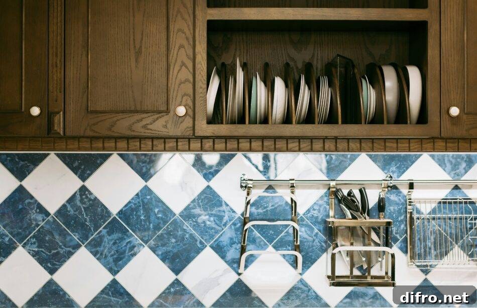 A close photo of some upper cabinets and the backsplash beneath them, white and blue diamond tiles.