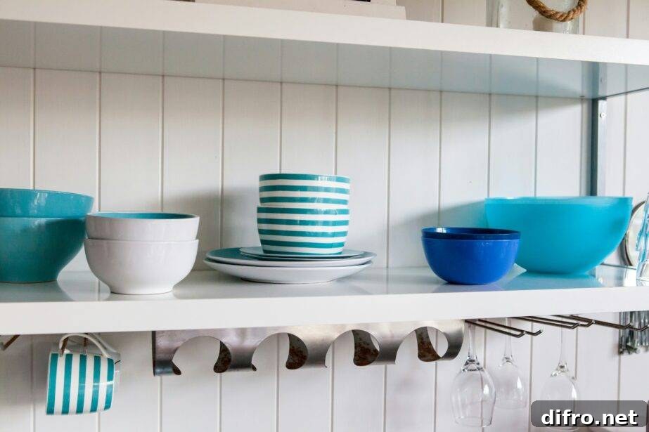 Open kitchen shelving with blue and white dishware stacked through it.