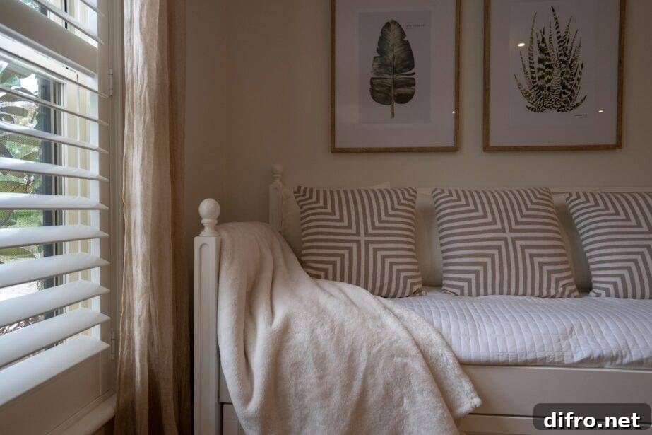 5 Space-Saving Hidden Bed Ideas to Keep a Guest Bed Ready 3 A daybed-style bed next to a window that's letting soft light in.