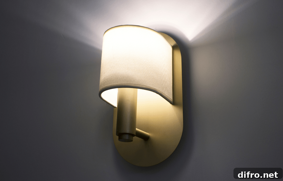 A modern wall sconce lit against a dark wall.