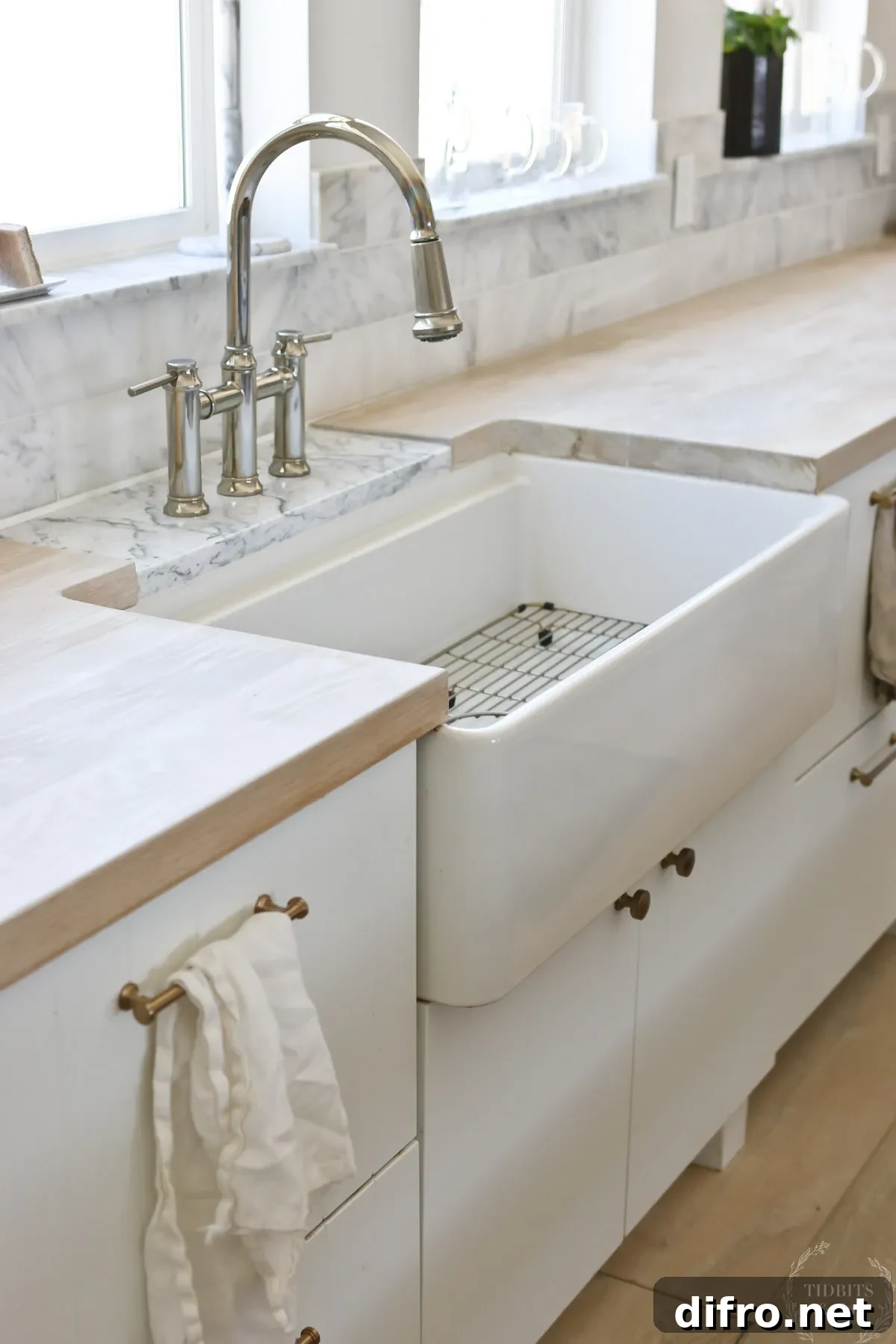 6 Countertop Materials That Look Just Like Marble 6 A farmhouse sink in the middle of a whitewashed butcher block countertop.