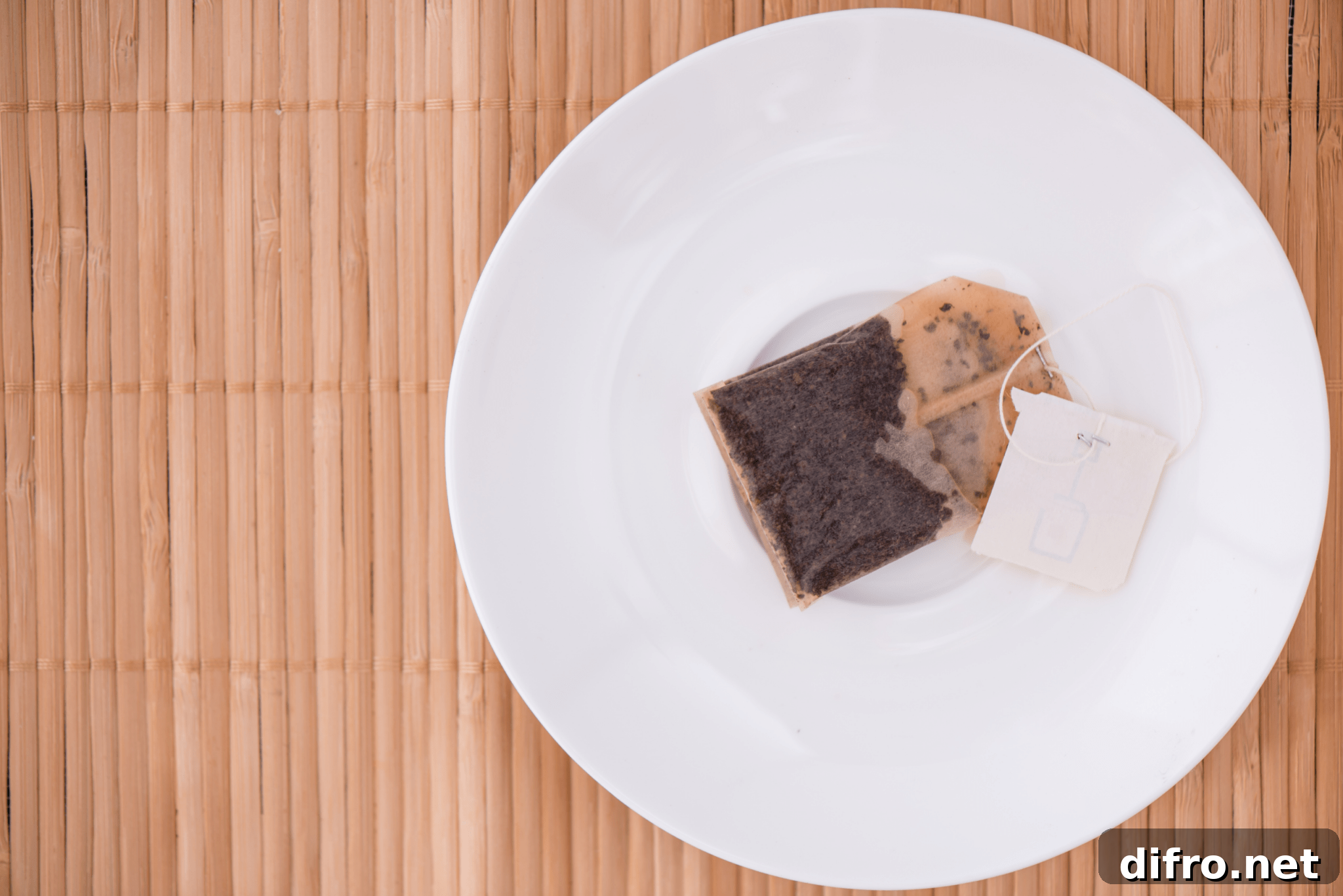 6 Smart Ways to Reuse Tea Bags for Home, Garden and Beauty 5 A used teabag on a plate.