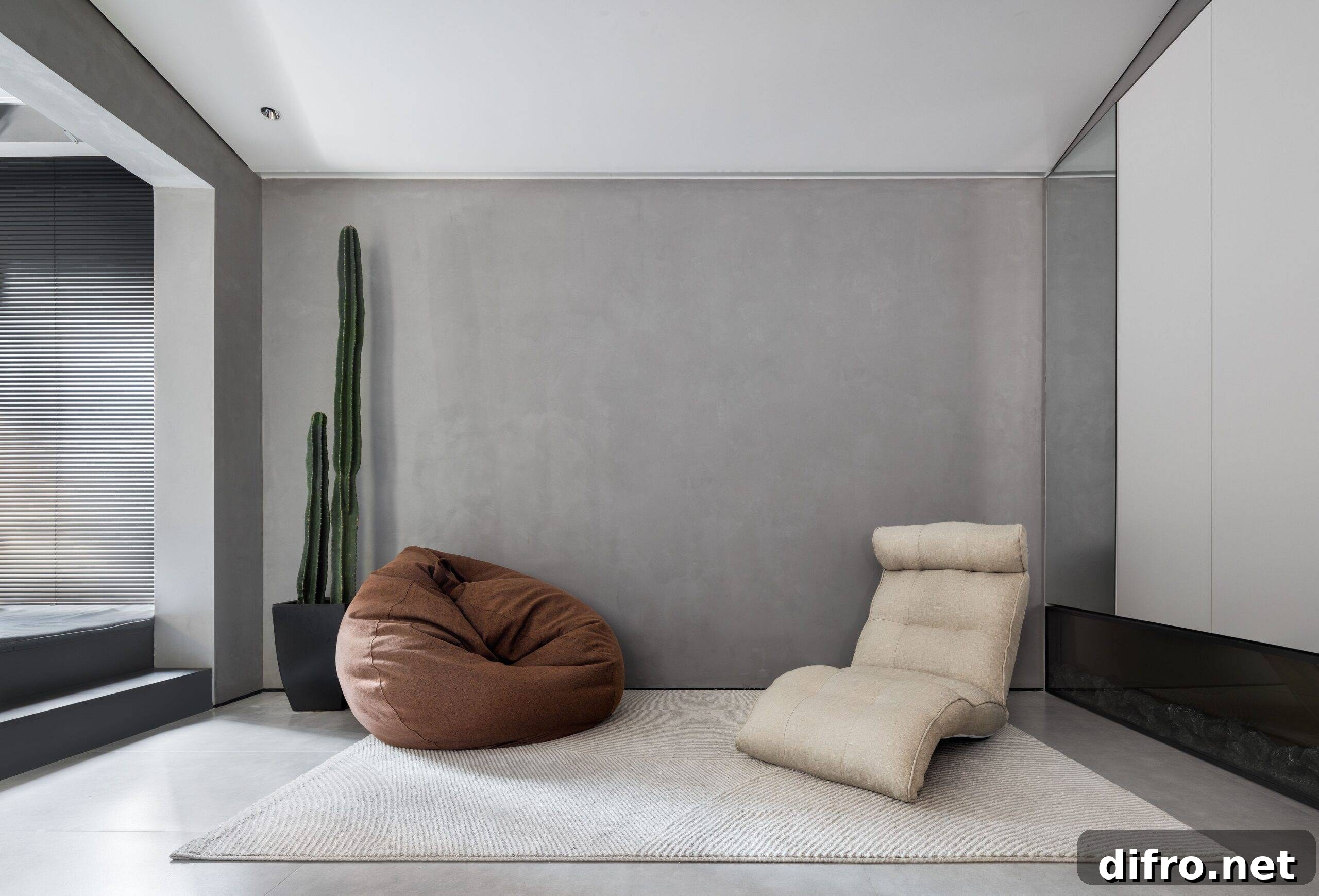 An interior with a decorative recliner and pouf next to a tall cactus plant