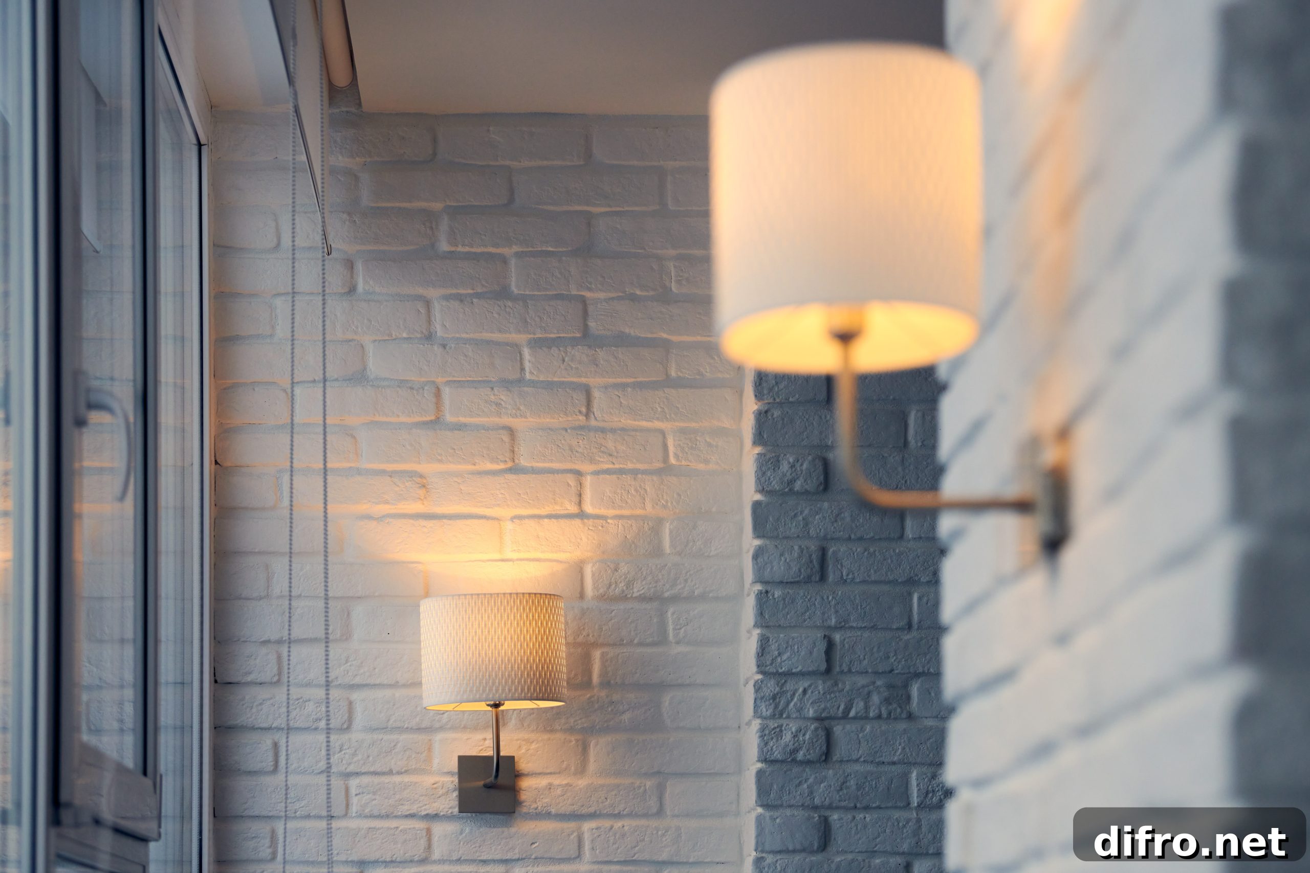 Wall lamp in modern loft apartment. Wall sconce on white brick wall. Yellow lights in shade. Evening, lights on.