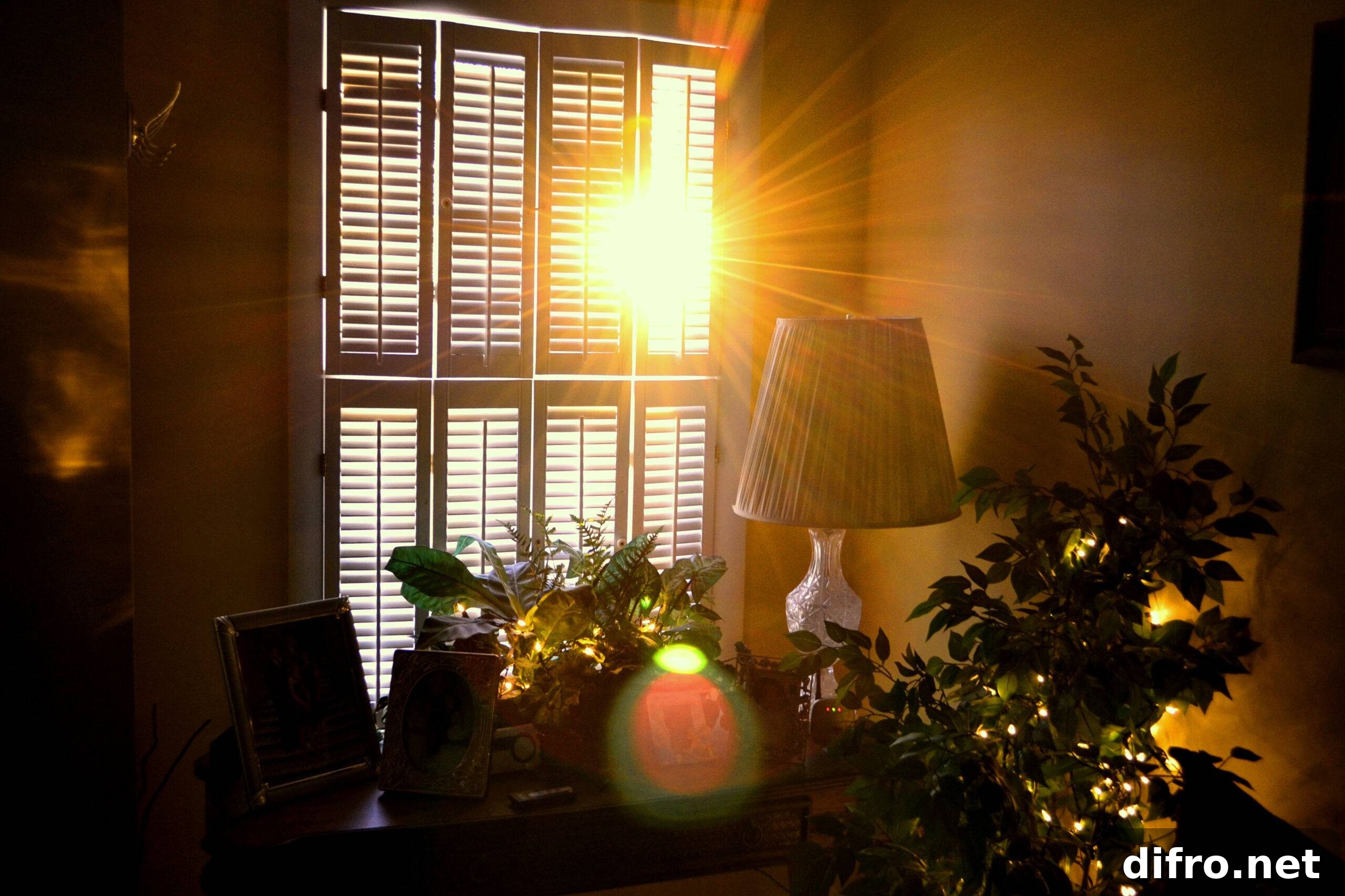 The sunlight shining into a room through semi-open blinds.