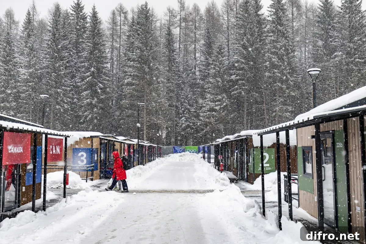 Snow falls as athletes walk at the Olympic Village ahead of the Milano Cortina 2026 Winter Olympics in Cortina d'Ampezzo