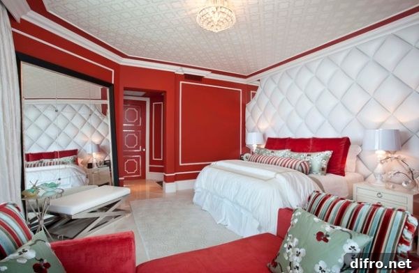 Hollywood Regency style bedroom with rich textiles and tufted wall along with bright red hues