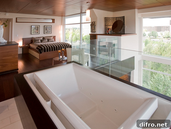 Bedroom with glass partition separating tub area